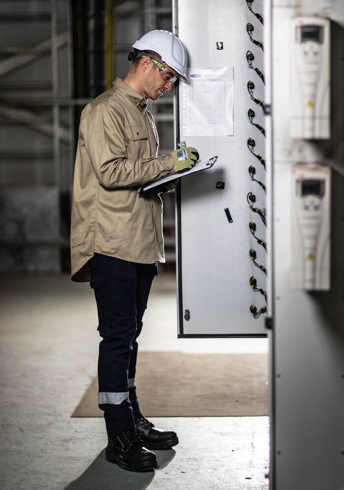 Técnico a registar dados junto a quadro técnico industrial